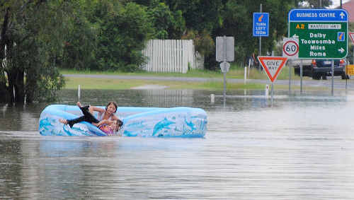 Two children play a dangerous game as they float down a swollen creek at Chinchilla. Two children play a dangerous game as they float down a swollen creek at Chinchilla.